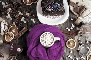 cup of hot chocolate on the table with sweets and chocolates photo