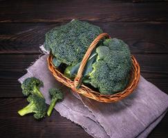 raw green cabbage broccoli in brown wicker basket photo
