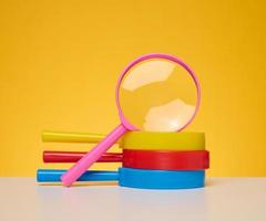 Stack of plastic magnifiers on yellow background photo