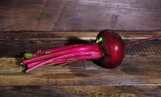 Whole raw red beet with tops photo