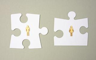 white puzzles and wooden men on a gray background. Recruitment concept, team compatibility, individuality. photo