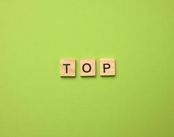 inscription top from wooden cubes on a green background photo