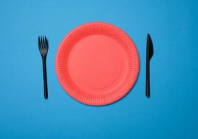 empty red paper disposable plates on a blue background photo