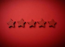 five red wooden stars on a red background photo