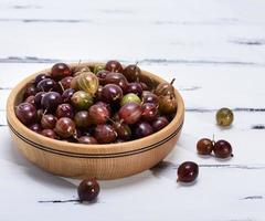 ripe red berries of gooseberries in a brown  bowl photo