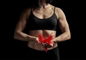 young girl with a muscular, athletic body is dressed in a black top and leggings photo