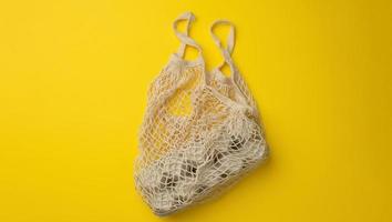 reusable white textile shopping bag with egg cartons on a yellow background, zero waste, photo