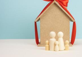 wooden house and miniature family figures, mortgage and loan concept photo