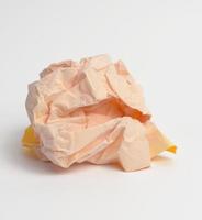 crumpled ball of yellow paper on white background photo