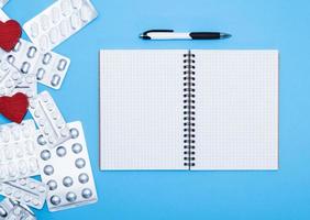 open notebook in the cell with empty white sheets and a pen photo