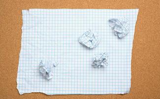 blank crumpled white sheet of paper in a cage and crumpled balls photo