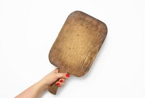 female hand with red manicure holds blank old vintage rectangular kitchen chopping board on white background photo