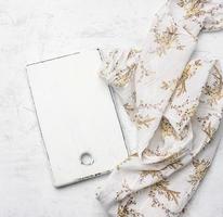 rectangular white cutting board on white textile tablecloth photo