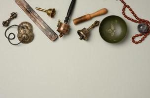 Tibetan singing copper bowl with a wooden clapper on a gray background, objects for meditation and alternative medicine, top view, photo