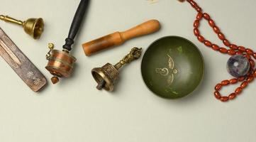 Tibetan singing copper bowl with a wooden clapper on a gray background, objects for meditation and alternative medicine photo
