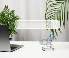 empty miniature shopping carts on white desk. Seasonal sale, online shopping photo