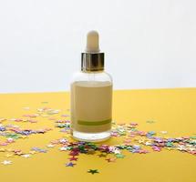 white glass bottle with a pipette and a empty white label. Container for cosmetics, serum and oil. Mockup skincare product photo