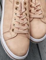 fragment of beige leather women's shoes with laces photo