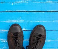 men's old sneakers on a blue wooden surface photo