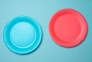 Empty blue, red paper disposable plates on a blue background, top view photo