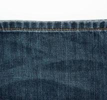 sewing line from brown threads on blue jeans photo