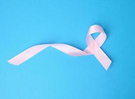 pink silk ribbon in the shape of a loop on a blue background photo