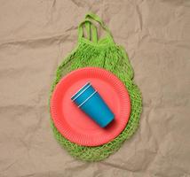 stack of blue paper cups and red round plates on a brown paper background photo