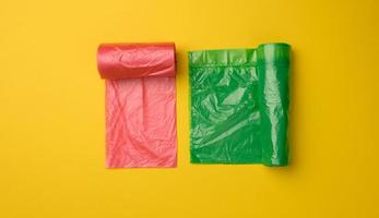 green and red plastic bags for trash can on yellow background photo