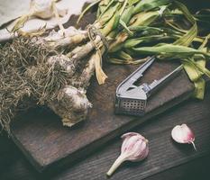 bunch of young garlic on a brown wooden board photo