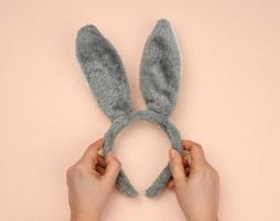 rabbit mask on the head with ears on a beige background, festive backdrop photo