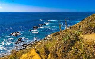 Beautiful rocks cliffs view waves at beach Puerto Escondido Mexico. photo