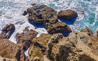 Beautiful rocks cliffs view waves at beach Puerto Escondido Mexico. photo