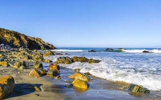 Beautiful rocks cliffs surfer waves at beach Puerto Escondido Mexico. photo