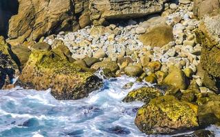 Beautiful rocks cliffs view waves at beach Puerto Escondido Mexico. photo