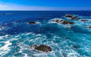 Beautiful rocks cliffs view waves at beach Puerto Escondido Mexico. photo