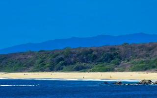 Beautiful rocks cliffs view waves at beach Puerto Escondido Mexico. photo