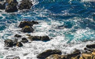 Beautiful rocks cliffs view waves at beach Puerto Escondido Mexico. photo