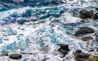 Beautiful rocks cliffs view waves at beach Puerto Escondido Mexico. photo