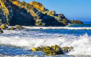 hermosas rocas acantilados olas surfistas en la playa puerto escondido mexico. foto