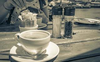 Cup of coffee on old wooden table restaurant at coast. photo