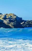 hermosas rocas acantilados olas surfistas en la playa puerto escondido mexico. foto