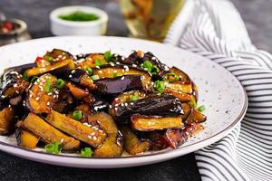 Hot spicy stew eggplant in Korean style with green onion. Aubergine saute. Vegan food. photo