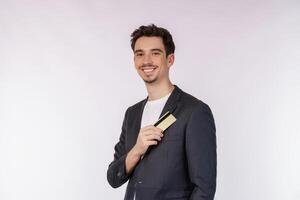 Portrait of Young smiling handsome businessman showing credit card isolated over white background photo