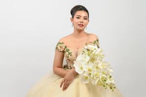 Young asian beautiful bride with orchid bouquet on white background photo