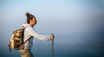 el retrato de una joven turista asiática está caminando en la cima del montaje y mirando un hermoso paisaje con espacio para copiar foto