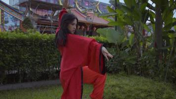 An Asian women practices martial art movement for the championship video
