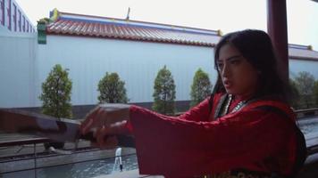une femme asiatique jouant avec l'épée d'argent avant la bataille avec son rival video