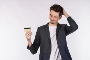 Portrait of unhappy businessman showing credit card isolated over white background photo