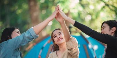 Group of women giving five to each other on camping photo