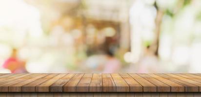 mesa de madera vacía y mesa de luz borrosa en cafetería y café con fondo de bokeh. plantilla de exhibición de productos. foto